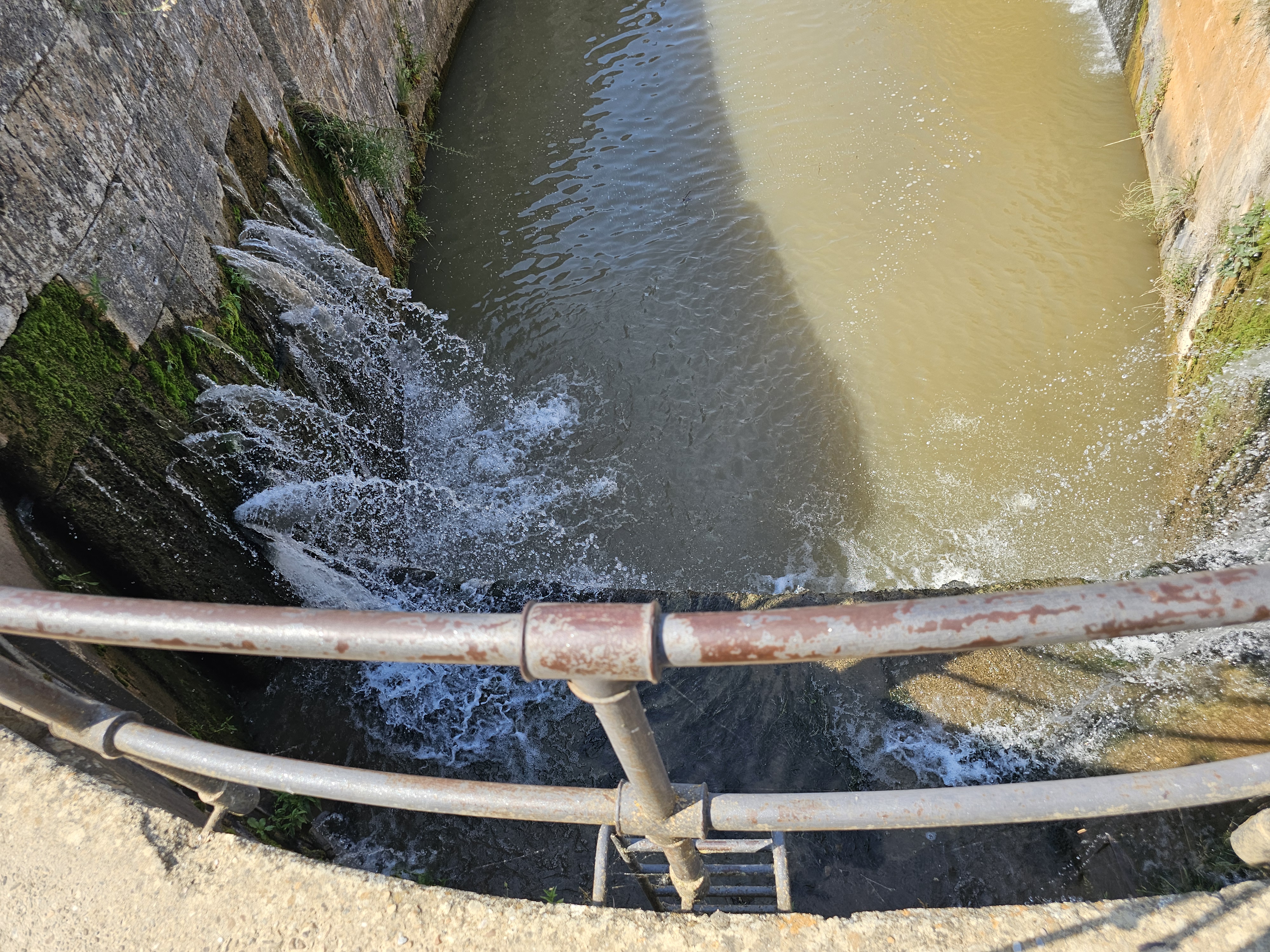 a dam partially broken and leaking water, picture taken from on top the dam