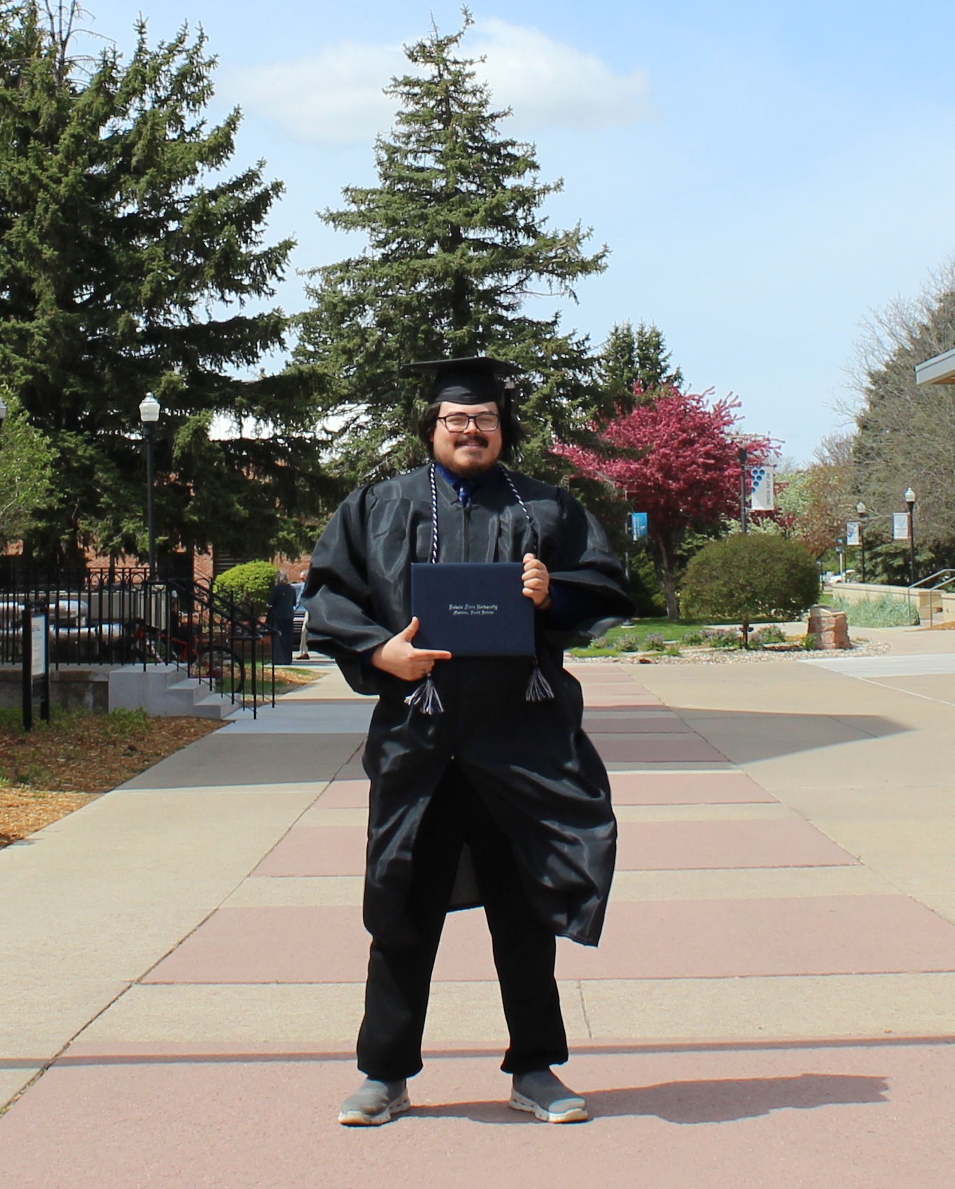 Author, Phoenix Campbell, standing in front of his alma mater.